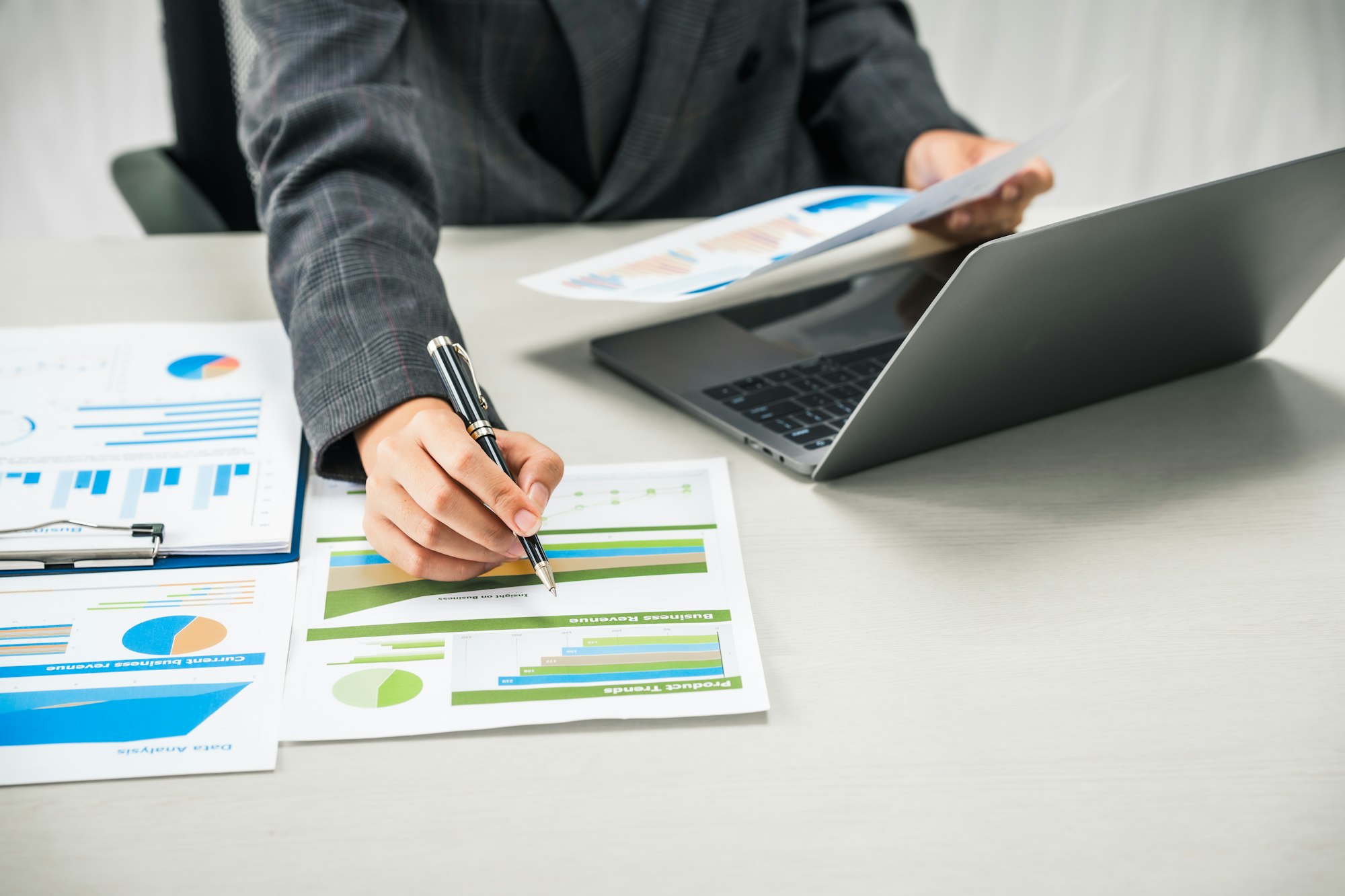 businesswoman works diligently at her desk, reviewing financial documents and analyzing investment